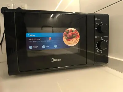 a microwave with a bowl of strawberries in it at The Excellent Axon Residence Bukit Bintang KL in Kuala Lumpur
