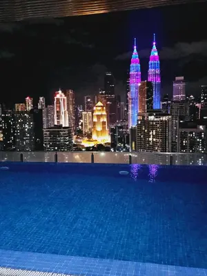 a swimming pool with a view of the city at night at Grand infinitum suites KLCC by PN in Kuala Lumpur