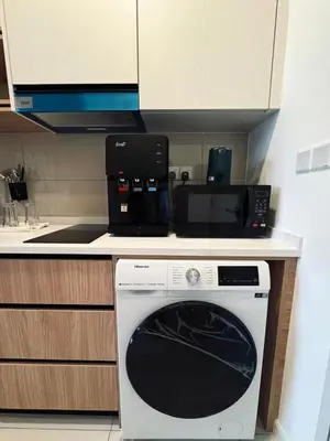 a kitchen with a microwave and a washing machine on a counter at Kampung Marsa Retreat, Majestic Residence, KL in Kuala Lumpur