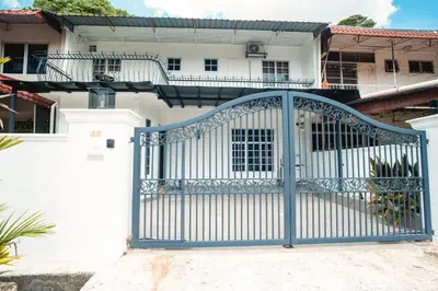 a blue gate in front of a white house at Seputeh 2Sty House - 10 min to MidValley KL Gateway Bangsar in Kuala Lumpur