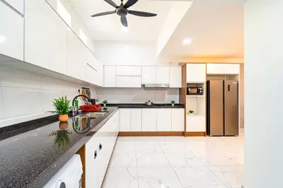 a kitchen with white cabinets and a ceiling fan at Seputeh 2Sty House - 10 min to MidValley KL Gateway Bangsar in Kuala Lumpur