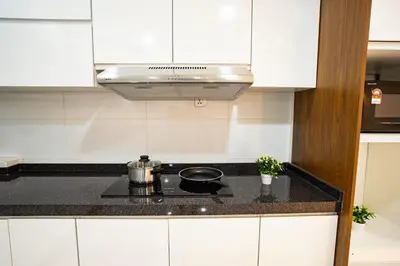 a kitchen with white cabinets and a stove top oven at Seputeh 2Sty House - 10 min to MidValley KL Gateway Bangsar in Kuala Lumpur