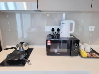 a kitchen counter with a toaster and a microwave at Isola KLCC Residence in Kuala Lumpur