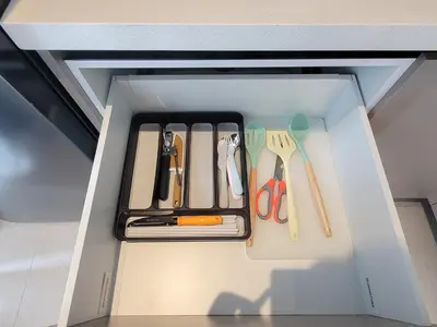 a drawer filled with utensils in a cabinet at Isola KLCC Residence in Kuala Lumpur