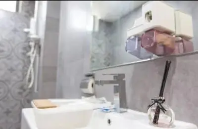 a person taking a picture of a mirror in a bathroom at BMC Arte Mont Kiara in Kuala Lumpur