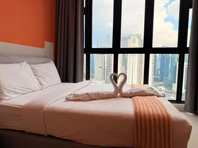 a bed with a heart shaped towel on it in front of a window at MH Rest House at Majestic Residence in Kuala Lumpur