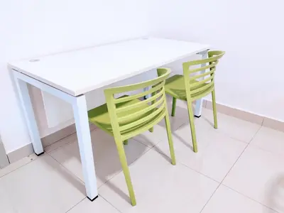 a white table and two green chairs sitting around it at Vivo Soho - 2 Bedrooms, Mid Valley, Bangsar South, Campus Rangers in Kuala Lumpur