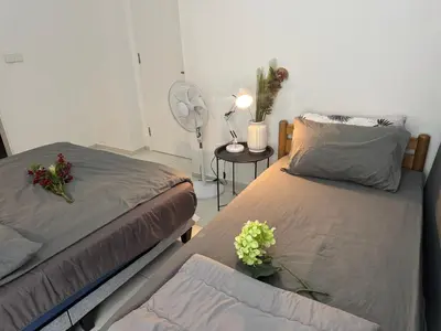 two beds in a room with flowers and a fan at Robertson S15 KLCC Alor Street Bukit Bintang 5Pax in Kuala Lumpur