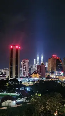 a city skyline at night with red lights at KL Nice Condo in Kuala Lumpur