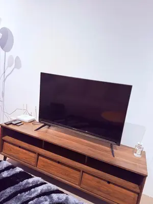a large flat screen tv on a wooden entertainment center at EST Establishment Bangsar in Kuala Lumpur