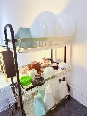a shelf with dishes and other items on it at EST Establishment Bangsar in Kuala Lumpur