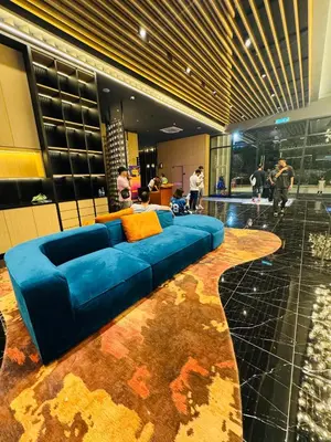 a blue couch in the middle of a lobby at Majestic Residence Klcc by Apple in Kuala Lumpur
