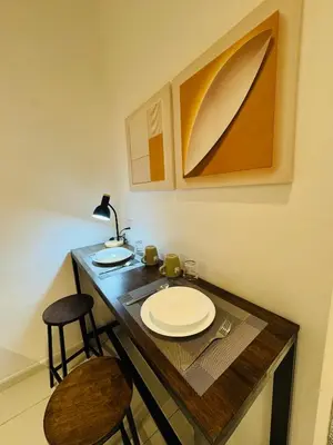 a table with a plate and a lamp and a chair at Majestic Residence Klcc by Apple in Kuala Lumpur