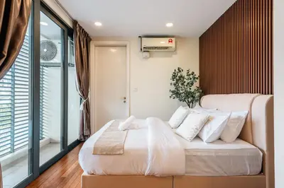a bedroom with a large bed with white sheets and pillows at The Noble Bungalow, 18pax 5R4B near Datuk Keramat, KL Pavilion in Kuala Lumpur