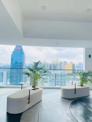 two tables and palm trees in a room with a large window at Majestic Residence KLCC by Nexus Suites in Kuala Lumpur
