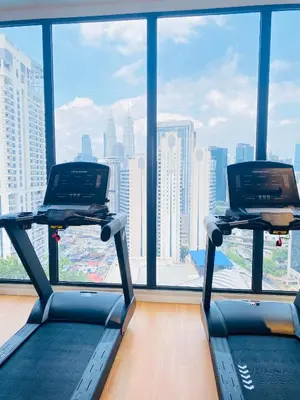 a gym with two treadmills in front of a large window at Majestic Residence KLCC by Nexus Suites in Kuala Lumpur