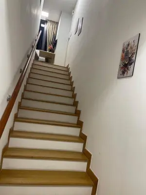 a staircase with white walls and wooden steps at INFINITUM Stay at klcc in Kuala Lumpur