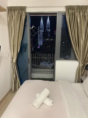 a bedroom with a bed and a view of the city at INFINITUM Stay at klcc in Kuala Lumpur
