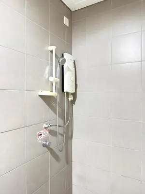 a shower in a bathroom with a hair dryer at CozyNest KLCC at Mercu Summer Suites in Kuala Lumpur