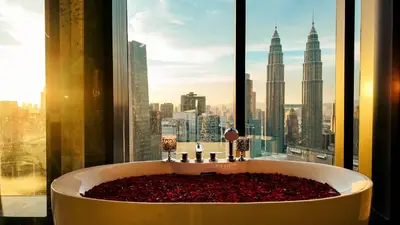 a bath tub in front of a window with a view at Imperial Residence KLCC - MJ Home in Kuala Lumpur
