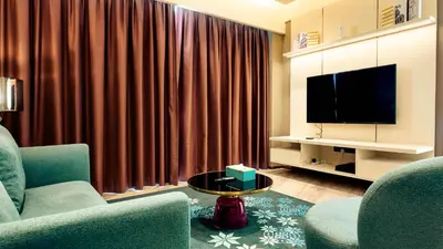 a living room with two chairs and a television at Imperial Residence KLCC - MJ Home in Kuala Lumpur