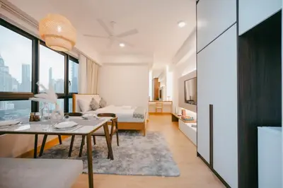 a living room with a table and a room with a bed at Cozy Minimalist Studio KL, Agile Residence Bukit Bintang in Kuala Lumpur
