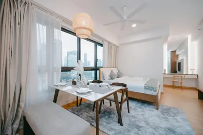 a living room with a table and a bed and a bedroom at Cozy Minimalist Studio KL, Agile Residence Bukit Bintang in Kuala Lumpur