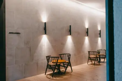 a row of chairs and tables against a wall with lights at Modern Cozy Home Kuala Lumpur, Agile Residence Bukit Bintang in Kuala Lumpur