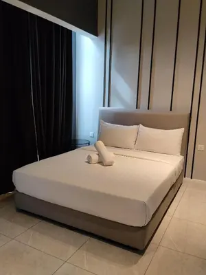 a bed with a white phone on top of it at Unitopia near KLCC pavillion in Kuala Lumpur