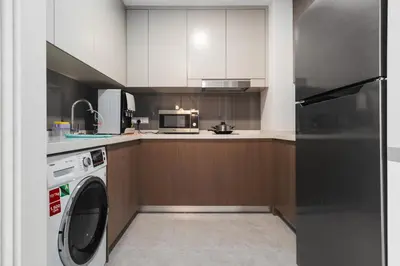 a kitchen with a washing machine and a microwave at Grand 2BR Agile Bukit Bintang BY RumaBnB in Kuala Lumpur