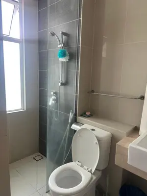 a bathroom with a toilet and a glass shower at Desa green apartment in Kuala Lumpur