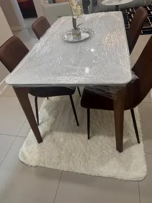 a dining table covered in plastic with four chairs at Desa green apartment in Kuala Lumpur