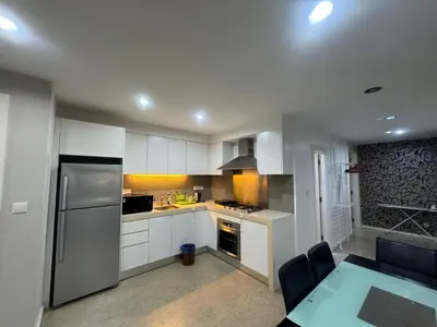 a kitchen with white cabinets and a stainless steel refrigerator at Fairlane Bukit Bintang by Lily in Kuala Lumpur