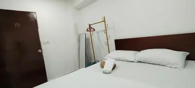 a bedroom with a bed with white sheets and a lamp at SHAMA HoTEL in Kuala Lumpur