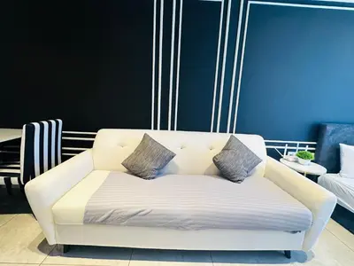 a white couch with three pillows on it in a room at Supper Suite By Axon Residence in Kuala Lumpur