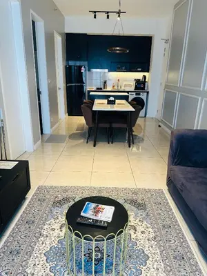 a living room with a table and a kitchen at Supper Suite By Axon Residence in Kuala Lumpur