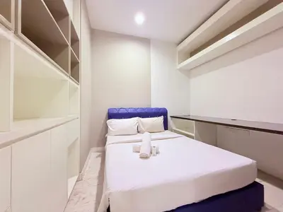 a white room with a bed and a blue chair at Platinum Klcc by StayAura in Kuala Lumpur
