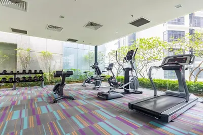 a gym with several treadmills and elliptical machines at Summer Suites KLCC Vibes in Kuala Lumpur