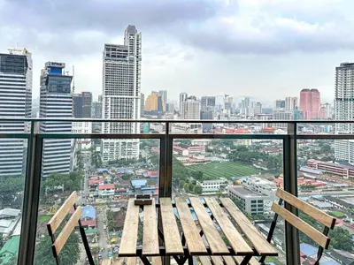 a bench on a balcony with a city skyline at Summer Suites KLCC Vibes in Kuala Lumpur