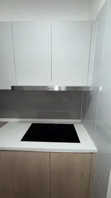 a kitchen with white cabinets and a stove top oven at M Arisa Sentul KL City view in Kuala Lumpur