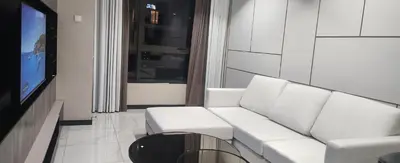 a living room with a white couch and a tv at Homestay at Wyndham Suites KLcc in Kuala Lumpur