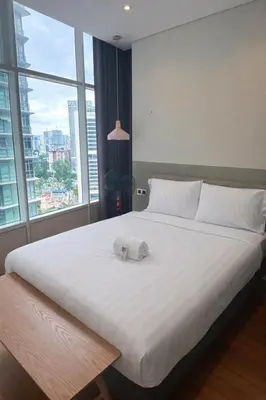 a large white bed with a towel on top of it at Sky Suites KLCC By Sky Management in Kuala Lumpur