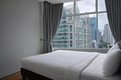 a bedroom with a white bed and a large window at Sky Suites KLCC By Sky Management in Kuala Lumpur