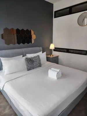a large white bed in a room with a lamp at Scarletz Suites KLCC Twin Tower by Skyview in Kuala Lumpur