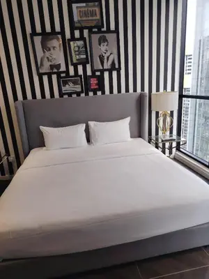 a large white bed in a bedroom with black and white stripes at Scarletz Suites KLCC Twin Tower by Skyview in Kuala Lumpur