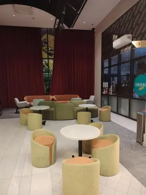 a waiting area with tables and chairs in a building at Scarletz Suites KLCC Twin Tower by Skyview in Kuala Lumpur