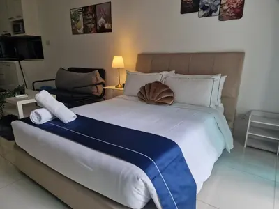 a bedroom with a large bed and a chair at Summer suites klcc 5 min walk by AA Global in Kuala Lumpur