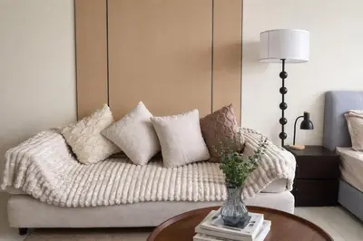 a living room with a couch with pillows and a table at Majestic KLCC By Flora in Kuala Lumpur