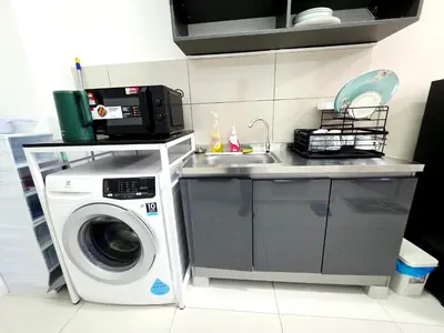 a kitchen with a washing machine and a sink at Majestic KLCC By Flora in Kuala Lumpur