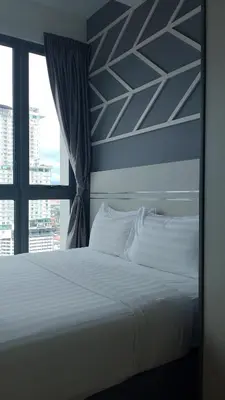 a bedroom with a white bed and a window at The Colony Infinitum KLCC Suits By Sabu in Kuala Lumpur